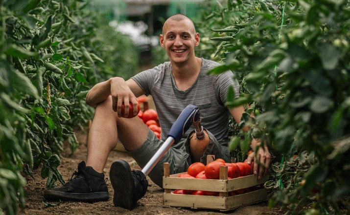 An amputee picking tomatoes